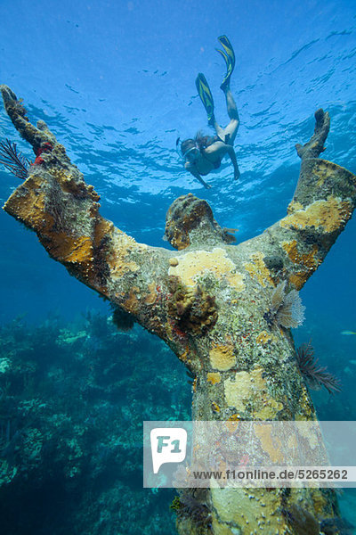 Snorkeler and underwater statue
