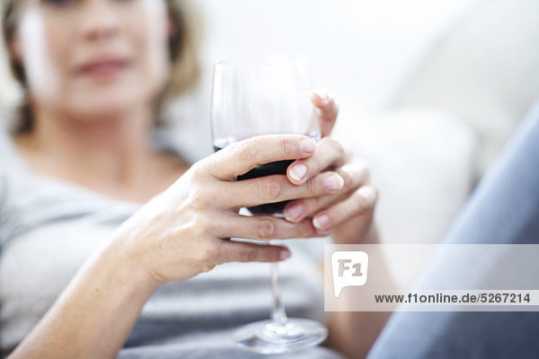Hände mit einem Glas Rotwein