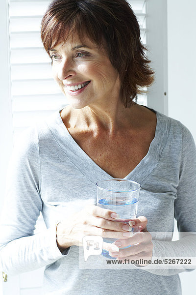 Porträt der Frau mit einem Glas Wasser