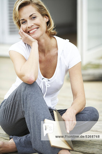 Reife Frau bei ihrer Beachouse ein Buch zu lesen