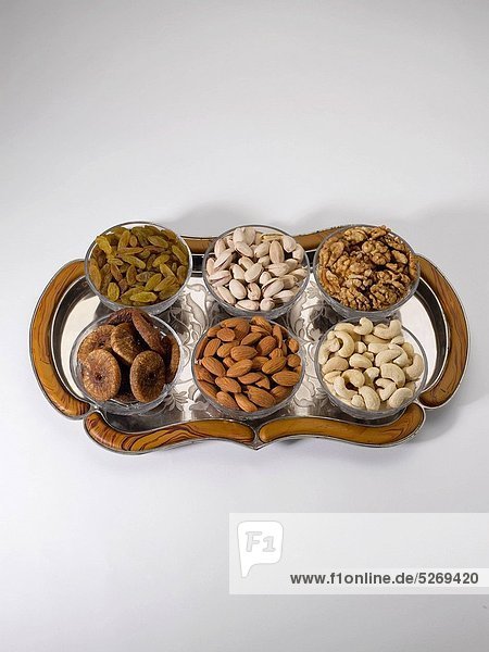Dry fruits and nuts   almonds pistachios walnuts raisins figs cashew nuts in bowls on tray