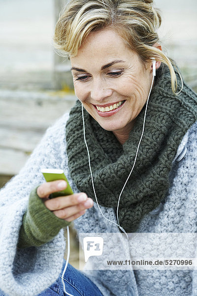 Mature Woman listening to iPod außerhalb