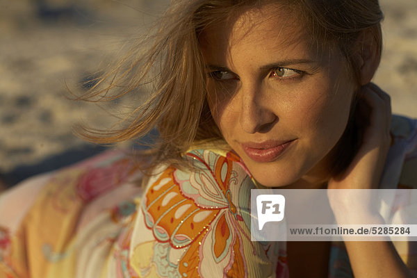 Beautiful Woman lying in Sand im Sonnenlicht verblassen