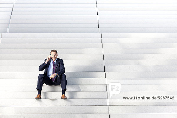 Telefonierender Geschäftsmann auf einer Treppe