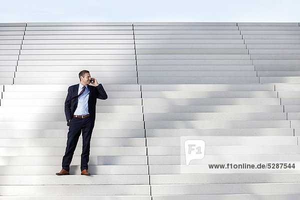 Businessman on the phone on stairs