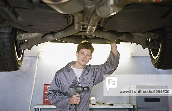 Mechanic working on car in garage