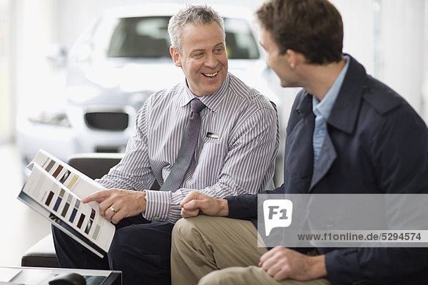 Car salesman talking with customer