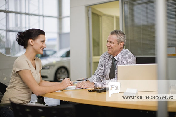 Woman talking with car salesman