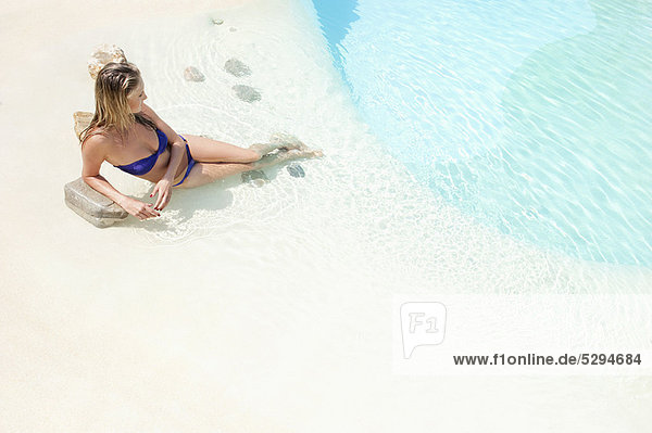 Frau entspannt sich am Schwimmbad
