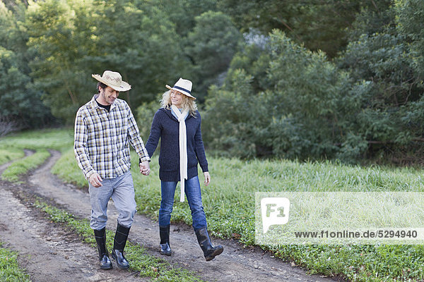 Smiling couple walking on dirt path