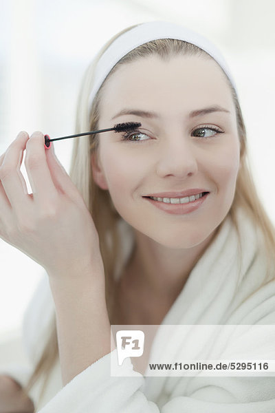 Smiling woman applying makeup
