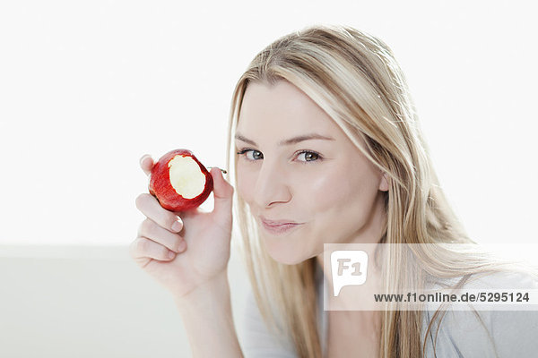 Lächelnde Frau beim Apfelessen