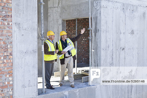 Businessman and worker talking on site