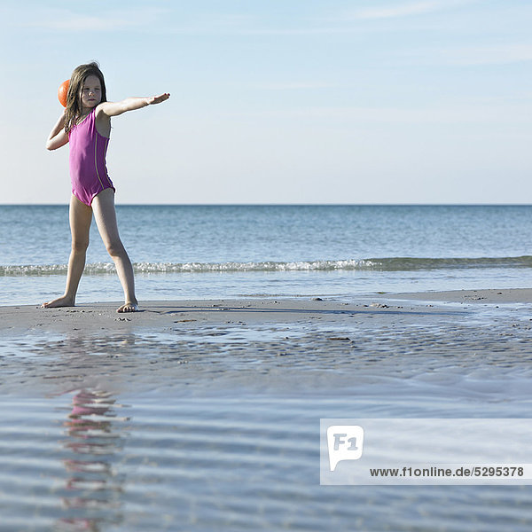Girl playing with ball on beach