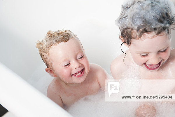 Children playing together in bubble bath