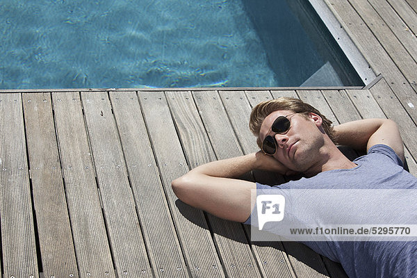 Man relaxing by swimming pool