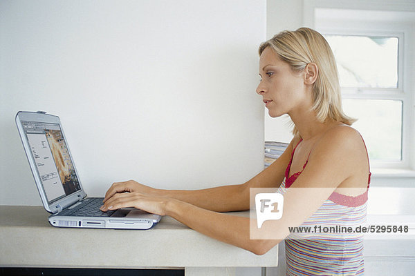 Woman using laptop on mantelpiece