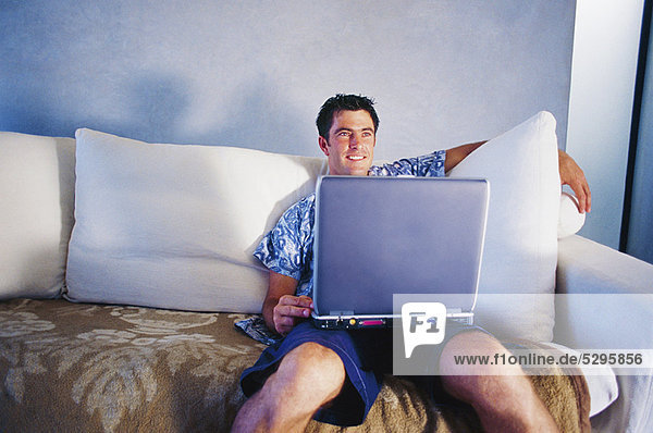 Man using laptop on couch