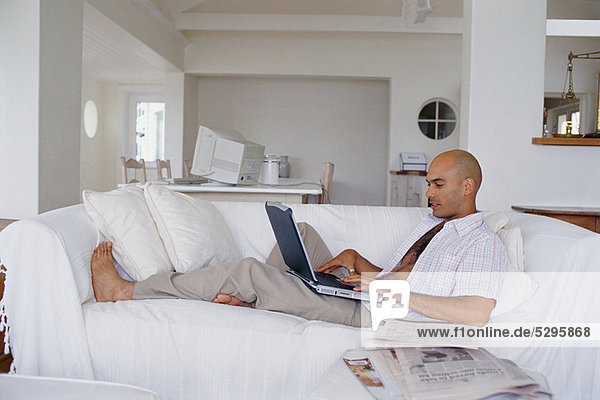 Man using laptop on couch