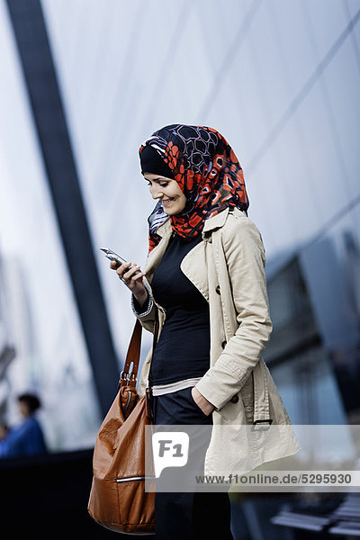 Woman in headscarf using cell phone