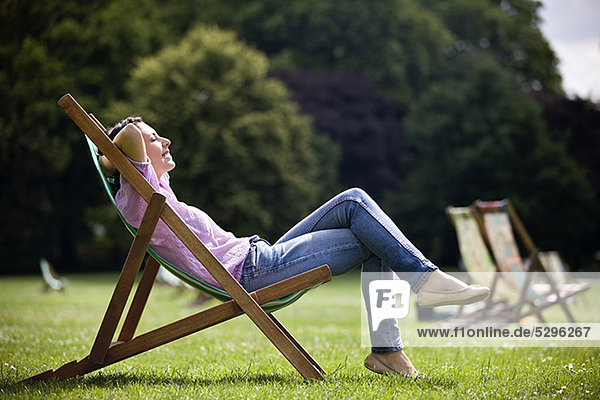 Eine junge Frau sitzt auf einem Liegestuhl, genießen die Sonne in St