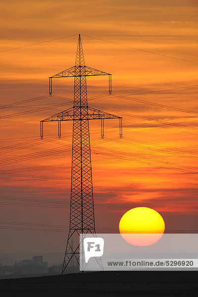 Electric power transmission lines  electricity pylon  with the setting sun  Beinstein near Stuttgart  Baden-Wuerttemberg  Germany  Europe