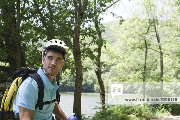 Mann mit Fahrradhelm im Wald