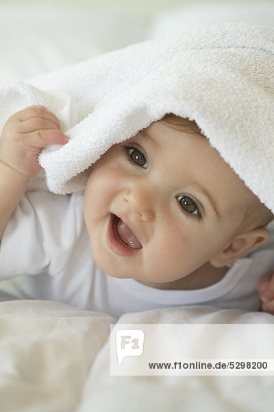 Baby peeking out from under blanket  portrait