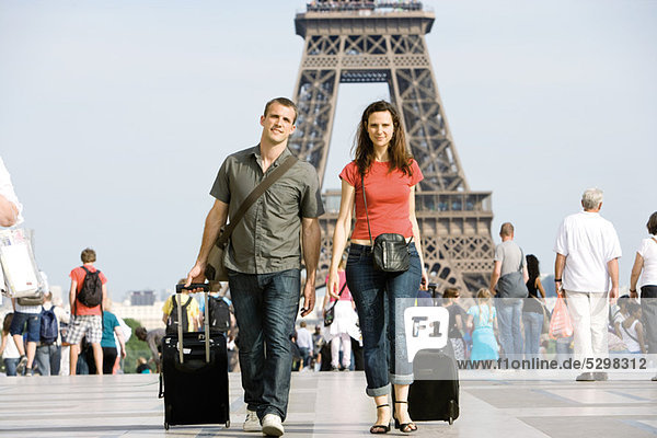 Touristenpaar mit Gepäck in der Nähe des Eiffelturms  Paris  Frankreich