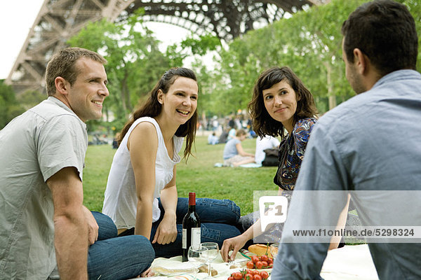 Friends enjoying picnic at base of Eiffel Tower  Paris  France