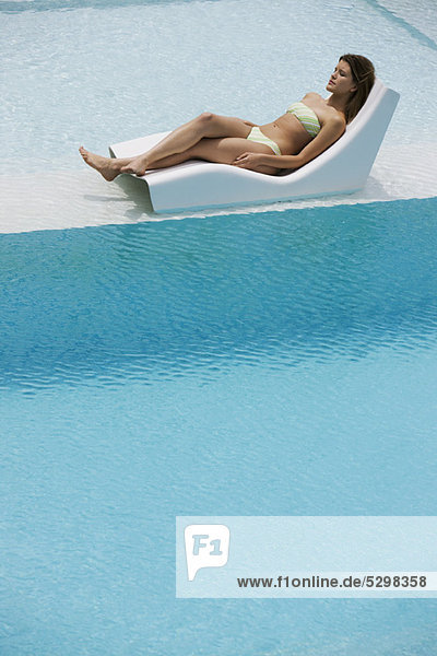Junge Frau beim Sonnenbaden am Pool