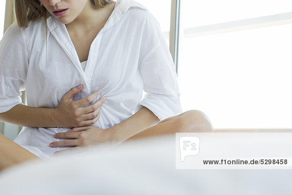 Woman experiencing abdominal pain  cropped