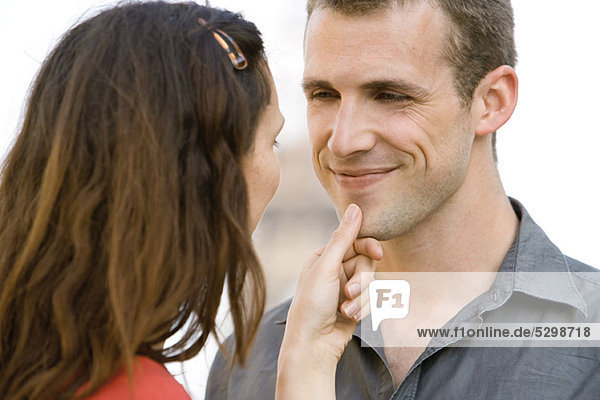 Woman caressing man's chin
