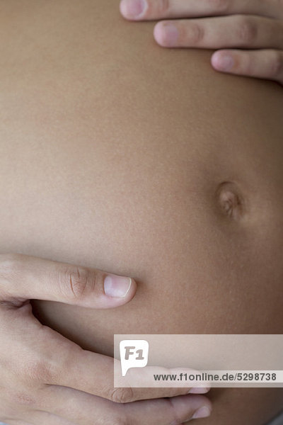 Schwangere Frau  die ihren Bauch berührt  abgeschnitten