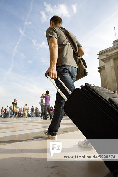 Man walking with rolling luggage