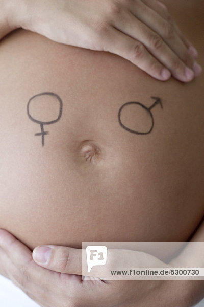 Männliche und weibliche Symbole  die auf den Bauch der Frau gezeichnet sind.