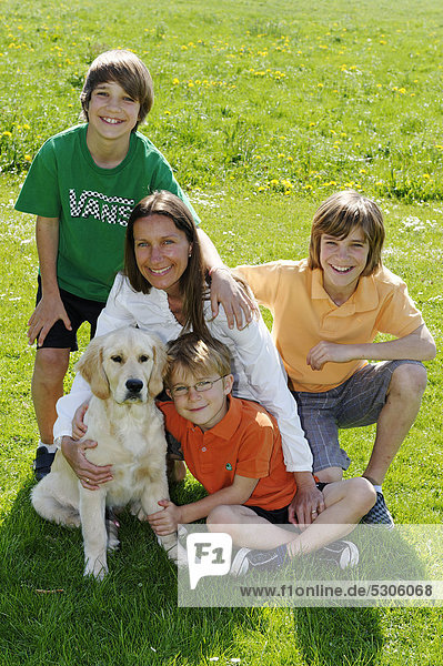 Mutter mit ihren drei Söhnen und Hund