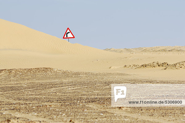 Verkehrsschild hinter Sanddüne zwischen Oase Farafra und Oase Dakhla  Libysche Wüste  Ägypten  Afrika