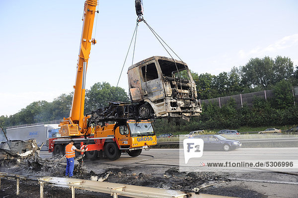 A burned-out truck engine being salvaged by a crane on the A8 motorway  Stuttgart  Baden-Wuerttemberg  Germany  Europe