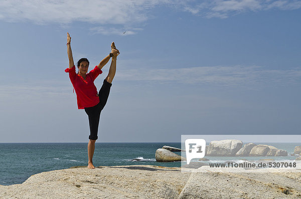 Woman in a yoga position  Anjaneyasana  by the sea in Kanyakumari  Tamil Nadu  India  Asia