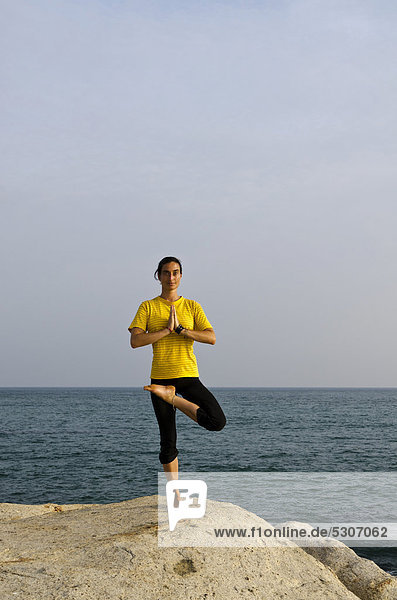 Frau in Yoga-Position Vrikshasana  am Meer in Kanyakumari  Tamil Nadu  Indien  Asien