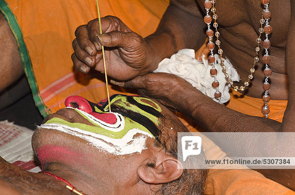 The make-up of the Kathakali character Ravana is being applied  Perattil  Kerala  India  Asia
