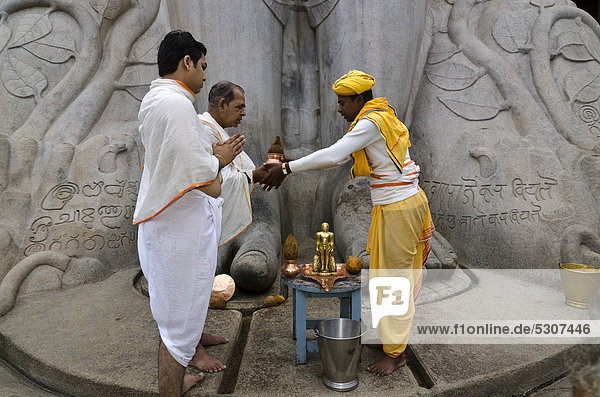 Pilgrims receive the blessings of Bahubali by a local priest on Indragiri hill in Sravanabelagola  Karnataka  India  Asia