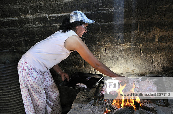 Bäuerin  49 Jahre  bereitet in ihrer einfachen Küche das Fleisch einer frisch geschlachteten Ziege zu  Puesto La Guascha  Gran Chaco  Salta  Argentinien  Südamerika