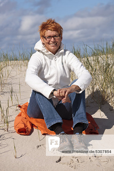 Frau sitzt in den Dünen  Insel Amrum  Nordfriesische Insel  Schleswig-Holstein  Deutschland  Europa