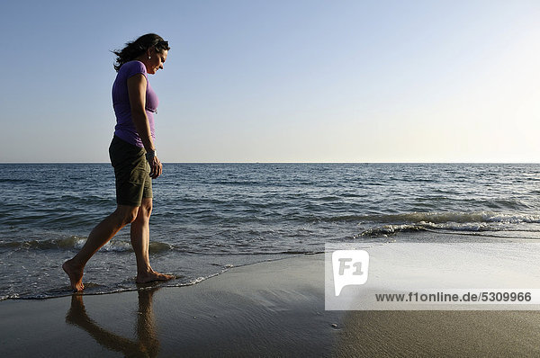 Frau spaziert über den Strand  Lido di Ostia  Rom  Latium  Italien  Europa