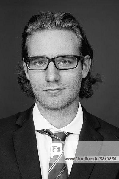 Junger Mann mit Brille im Businessanzug  Porträt