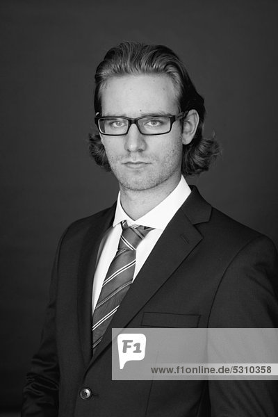 Junger Mann mit Brille im Businessanzug  Porträt