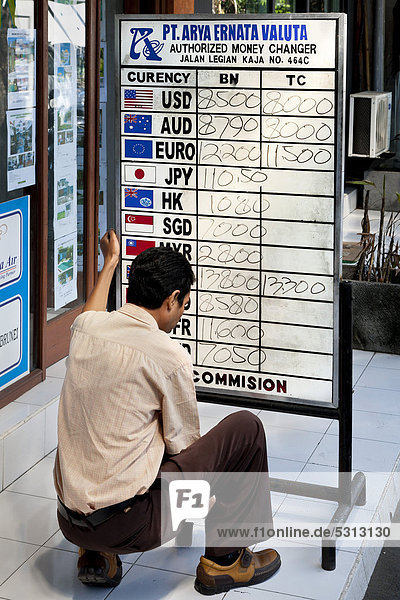 Mann liest Wechselkurse an einer Tafel  Kuta  Südbali  Insel Bali  Indonesien  Südostasien  Asien