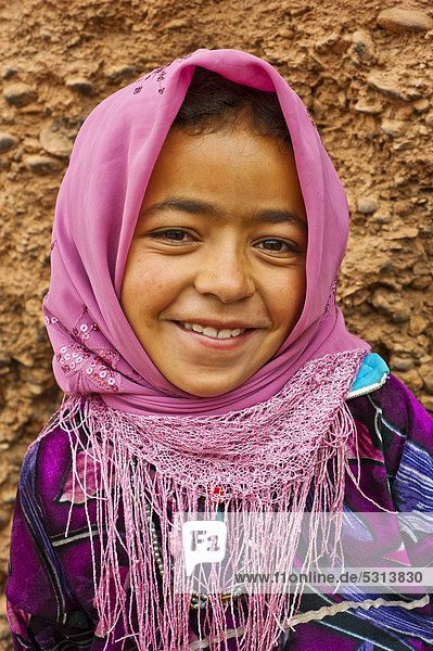Portrait of a smiling young girl wearing a pink head scarf  nomadic cave-dweller  Berber  Dades Valley  High Atlas Mountains  southern Morocco  Morocco  Africa